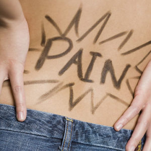Rear view of woman with hands on lower back with Pain written on it